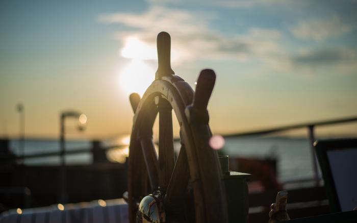 brown wooden ship's wheel by orbtal media courtesy of Unsplash.